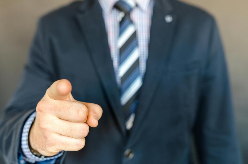 pexels-photo-652355-652355 A businessman in a dark suit points forward, emphasizing focus and professionalism.